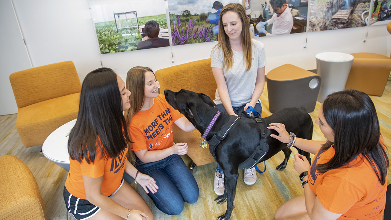 Students with a black Labrador Retriever