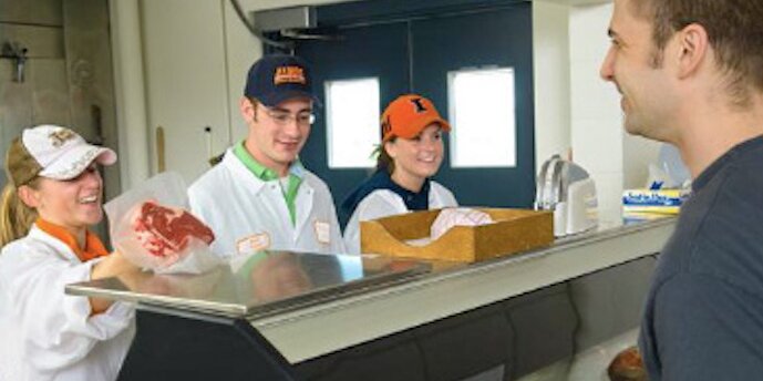 Students selling steak to a customer in the Meat Science Lab
