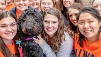 group of students posing with dog