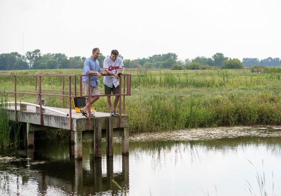 Student and instructor examining a pond