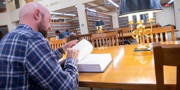 Student reading through a book