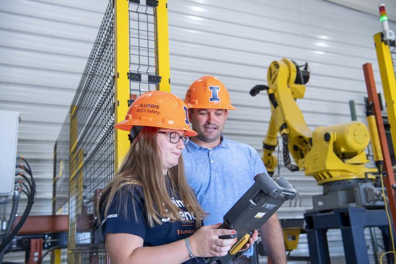 Student and instructor in hard hats in an industrial setting.