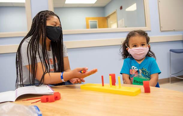 Student working with a daycare child