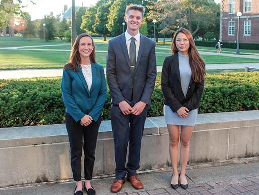 Three students standing by the south quad