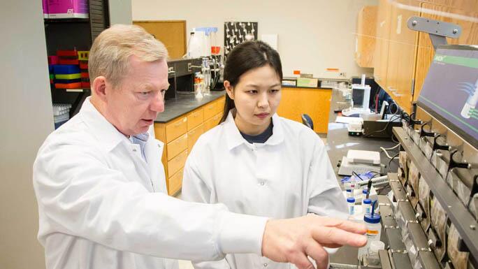 Instructor working with a student in a lab